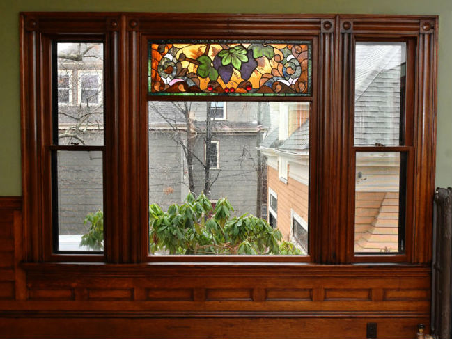 Restored stained glass window at 83 Belmont St. with grapevine pattern