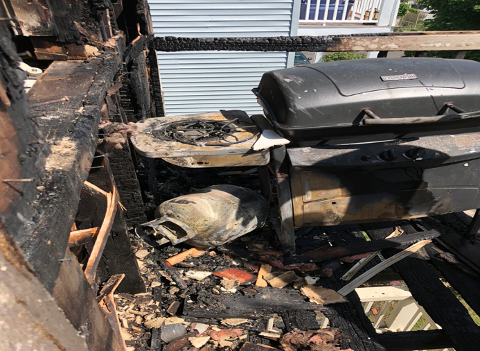 A charred porch illustrates the danger of using a grill on a balcony, which is prohibited in Somerville.