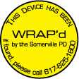 Small, circular yellow WRAP sticker reads: THIS DEVICE HAS BEEN WRAP'd by the Somerville PD. If found, please call 617-625-1600