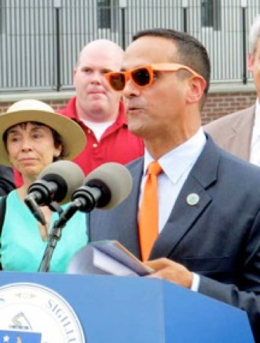 Mayor Curtatone dons an orange tie and orange sunglasses at the Somerville Green Tech introduction.