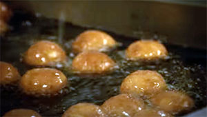 Donut holes cooking in a fryer
